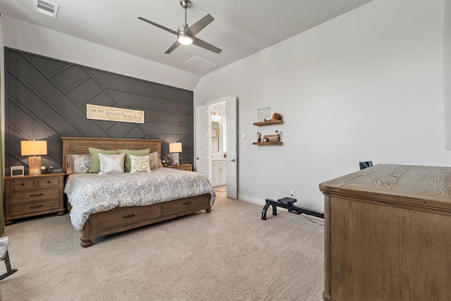 carpeted bedroom featuring ceiling fan, lofted ceiling, and ensuite bath