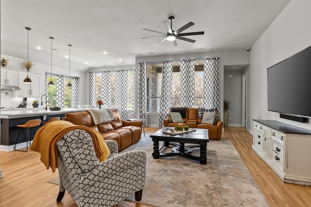 living room with ceiling fan and light wood-type flooring