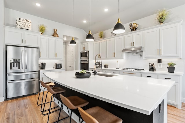 kitchen featuring stainless steel appliances, white cabinetry, sink, and a kitchen island with sink