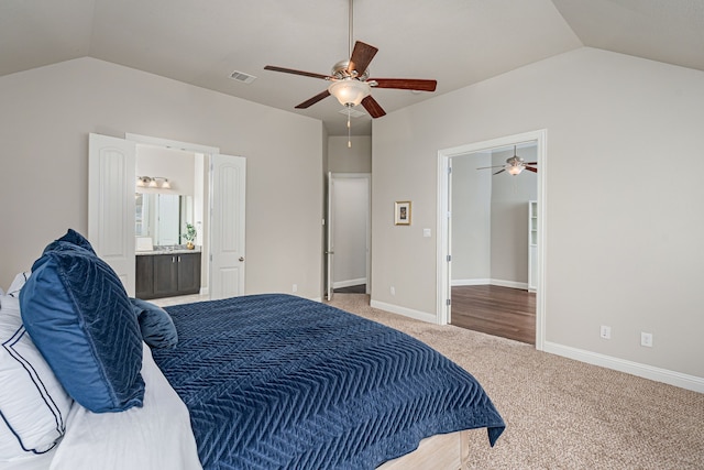 bedroom with vaulted ceiling, ensuite bathroom, ceiling fan, and carpet flooring