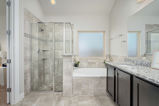 bathroom with vaulted ceiling, separate shower and tub, and vanity