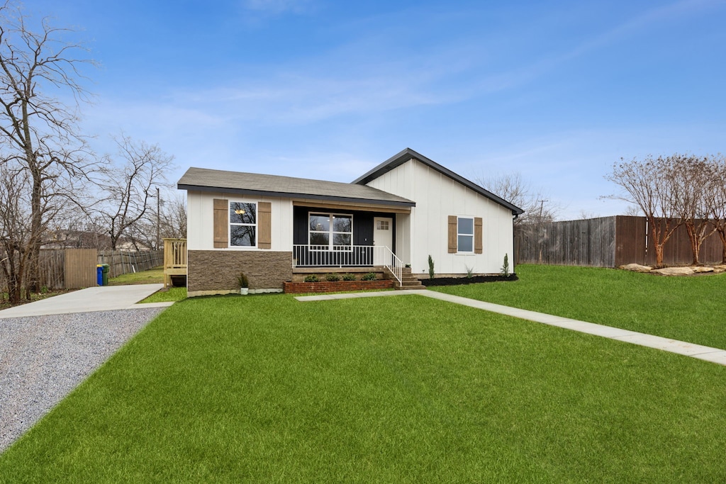 single story home featuring covered porch and a front lawn