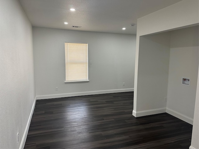 unfurnished room with dark wood-type flooring