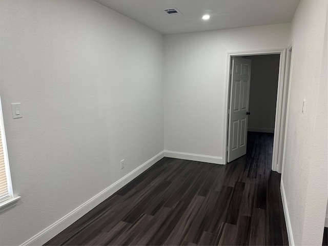 empty room with dark hardwood / wood-style flooring