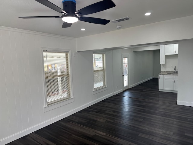 empty room featuring dark hardwood / wood-style flooring, sink, and ceiling fan