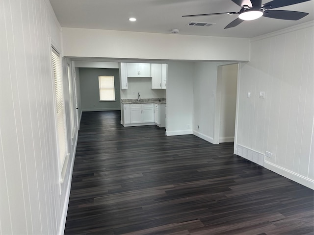 unfurnished living room featuring dark hardwood / wood-style flooring, sink, and ceiling fan