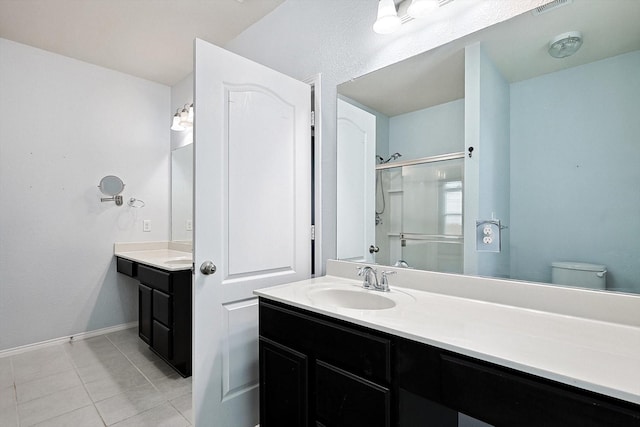 bathroom featuring tile patterned flooring, vanity, walk in shower, and toilet