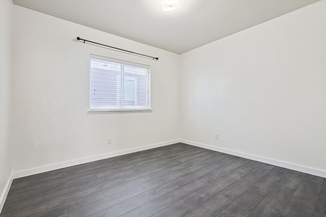 spare room with dark hardwood / wood-style floors and a textured ceiling