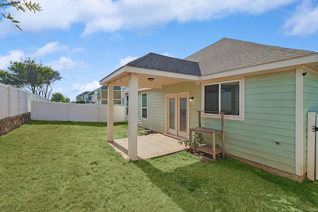 rear view of house with a lawn and a patio