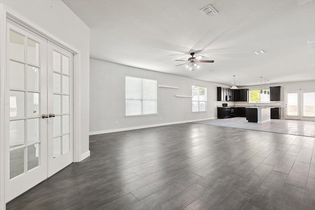 unfurnished living room featuring dark hardwood / wood-style flooring, plenty of natural light, and ceiling fan