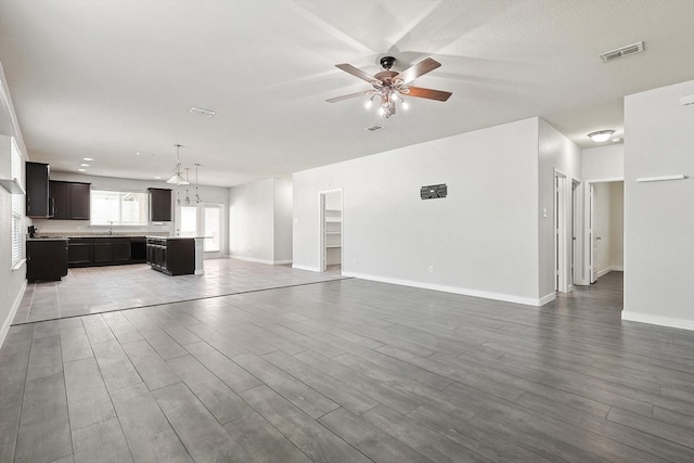 unfurnished living room with hardwood / wood-style floors and ceiling fan with notable chandelier