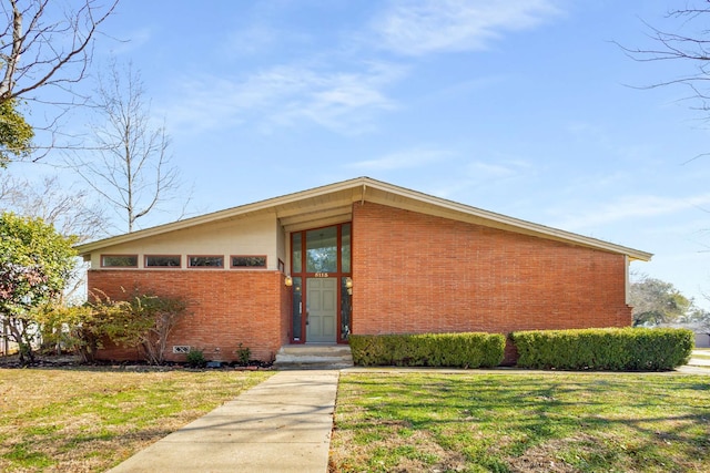 mid-century inspired home with a front lawn and brick siding