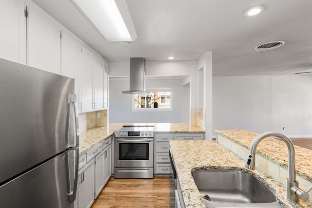 kitchen featuring island range hood, sink, white cabinets, stainless steel appliances, and light wood-type flooring