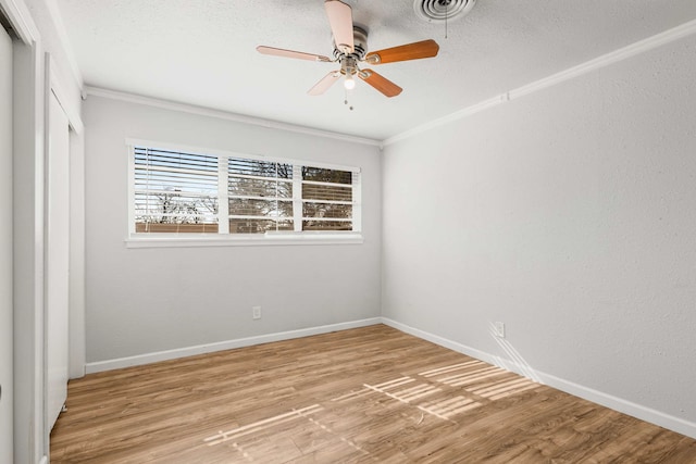 spare room with crown molding, ceiling fan, wood-type flooring, and a textured ceiling