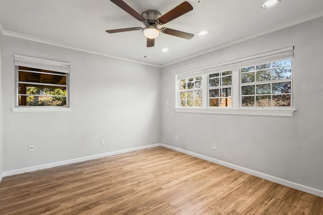 spare room featuring crown molding, wood-type flooring, and a wealth of natural light