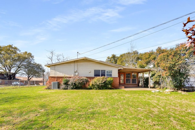 rear view of house with cooling unit, a yard, and a patio area