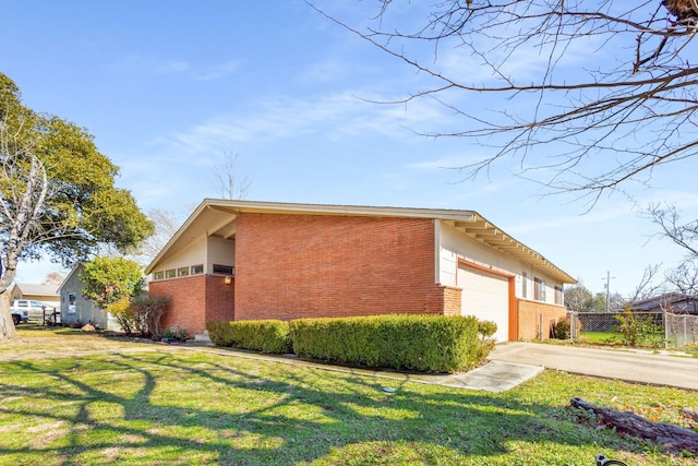 view of side of home featuring a garage and a lawn