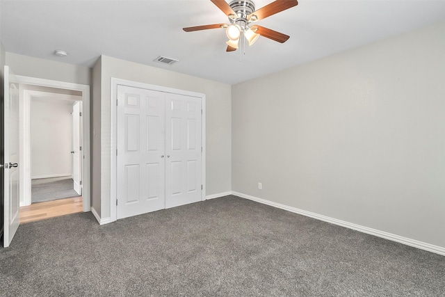 unfurnished bedroom featuring a closet, ceiling fan, and dark colored carpet