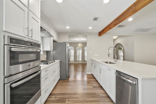 kitchen with sink, stainless steel appliances, hardwood / wood-style floors, and white cabinets