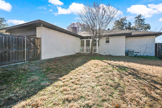 back of property with a yard and central air condition unit