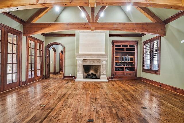 unfurnished living room featuring hardwood / wood-style flooring and lofted ceiling with beams