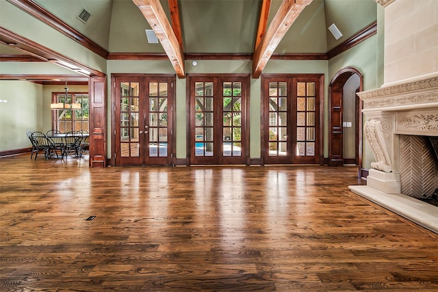 unfurnished living room with beam ceiling, dark wood-type flooring, french doors, and a high ceiling