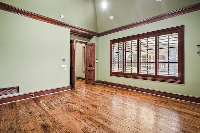 spare room with hardwood / wood-style flooring and a towering ceiling