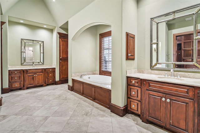 bathroom with lofted ceiling, a bath, vanity, and tile patterned floors