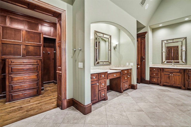 bathroom featuring tile patterned floors, lofted ceiling, and vanity