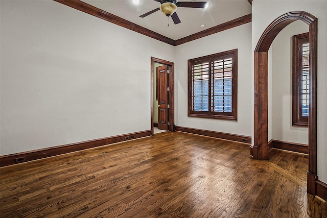 empty room featuring crown molding, ceiling fan, and dark wood-type flooring