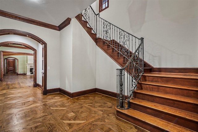 stairs with parquet floors and ornamental molding