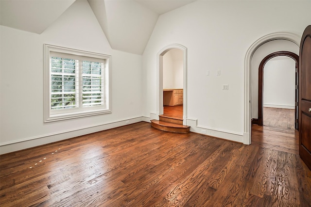 unfurnished living room featuring dark hardwood / wood-style flooring and vaulted ceiling