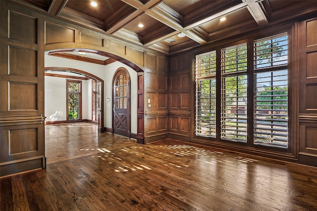 foyer entrance featuring crown molding, beam ceiling, coffered ceiling, dark hardwood / wood-style flooring, and wood walls