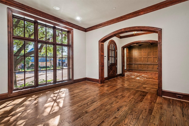 spare room with dark wood-type flooring and ornamental molding