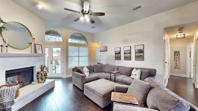 living room with a brick fireplace, dark hardwood / wood-style floors, and ceiling fan