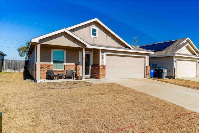 view of front of house with a garage, a front lawn, and covered porch