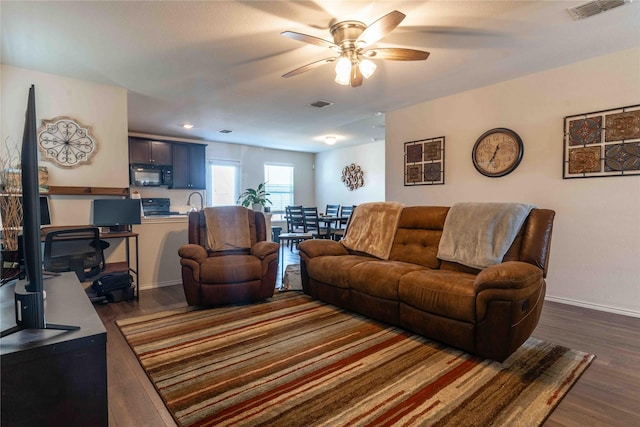 living room with dark hardwood / wood-style floors and ceiling fan