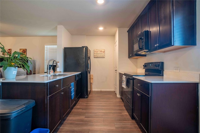 kitchen featuring sink, black appliances, dark hardwood / wood-style floors, and kitchen peninsula