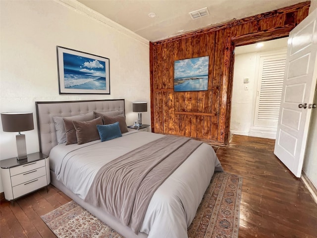 bedroom featuring crown molding and dark wood-type flooring