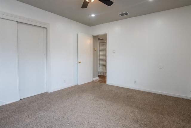 unfurnished bedroom with ceiling fan, carpet flooring, and a closet