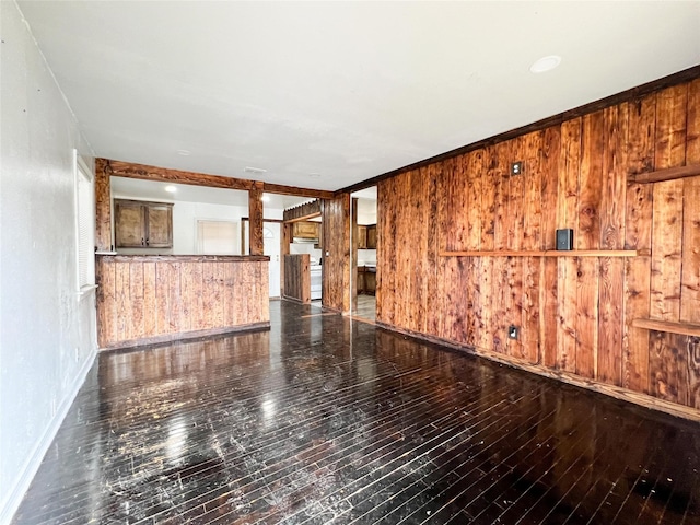 empty room featuring wood-type flooring and wooden walls