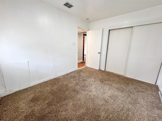 unfurnished bedroom with carpet floors and a closet