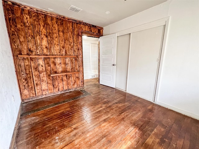 unfurnished bedroom featuring dark hardwood / wood-style floors and a closet