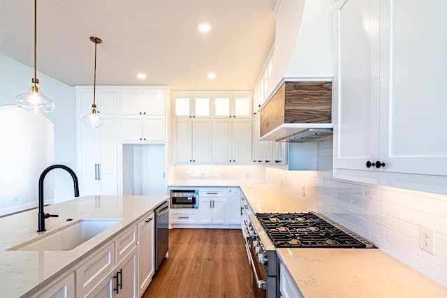 kitchen featuring sink, white cabinetry, light stone counters, hanging light fixtures, and stainless steel appliances