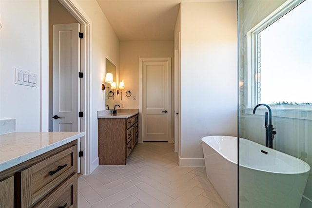 bathroom with vanity, parquet flooring, and a bathtub