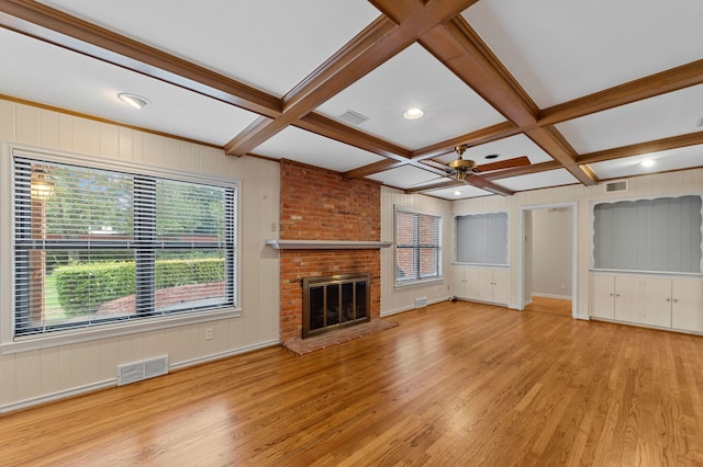 unfurnished living room featuring coffered ceiling, a fireplace, and light hardwood / wood-style floors