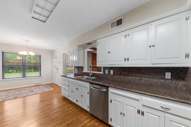 kitchen featuring decorative light fixtures, white cabinetry, dishwasher, sink, and dark stone countertops