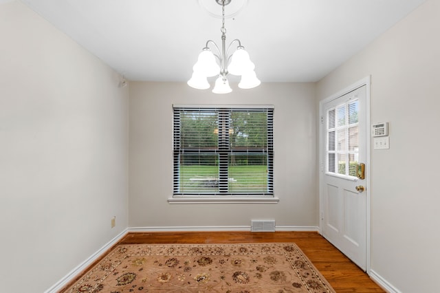 unfurnished dining area with light hardwood / wood-style flooring and a notable chandelier