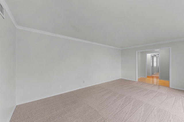 spare room featuring crown molding and light colored carpet