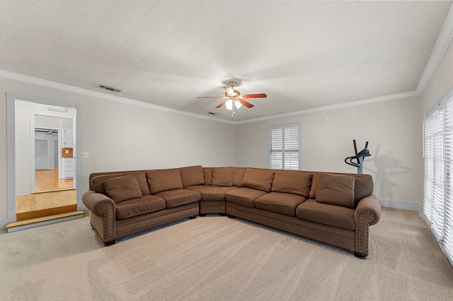 living room featuring light carpet, ceiling fan, crown molding, and a textured ceiling